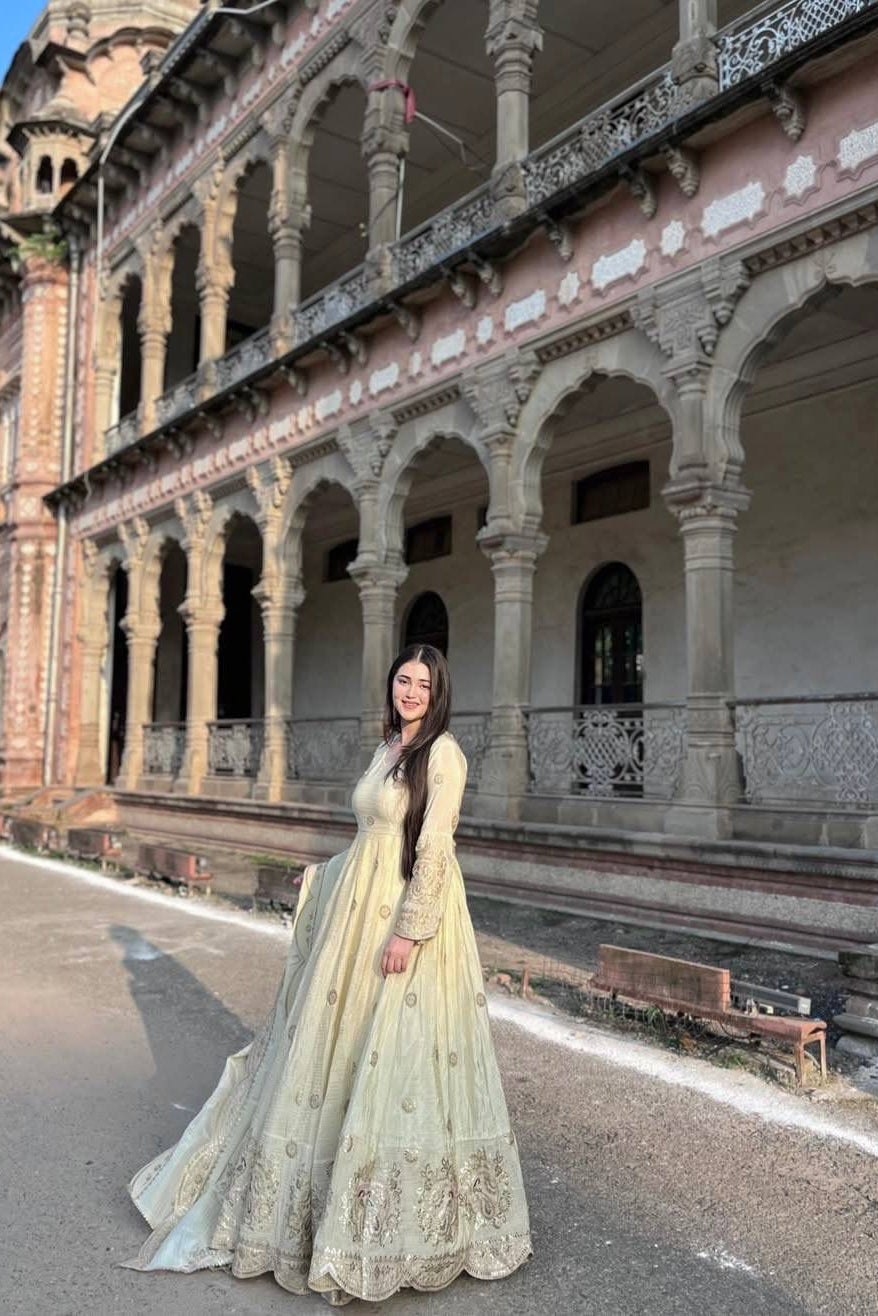 Chinon silk Anarkali dress shown in a full-length outdoor view with ornate embroidered hem
