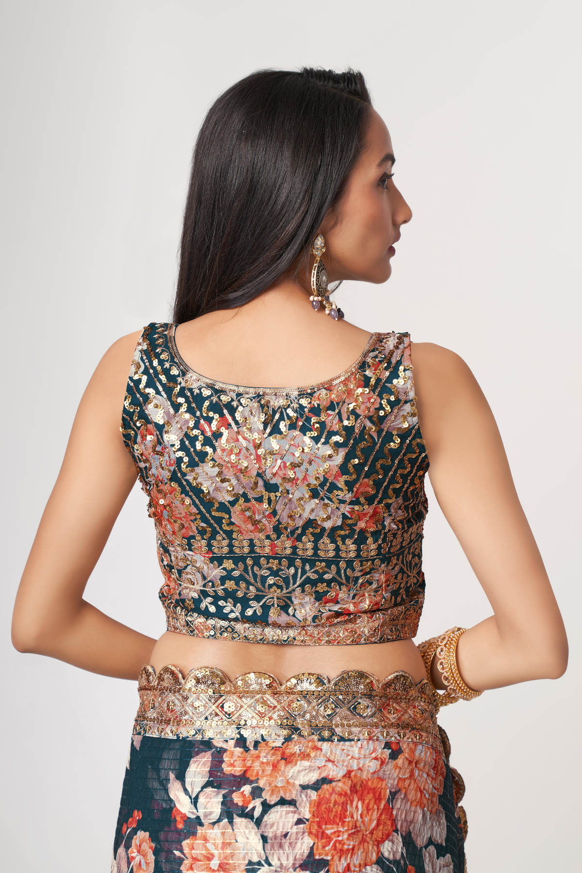 Back view of a deep teal floral organza saree showing the printed pallu and embellished blouse design