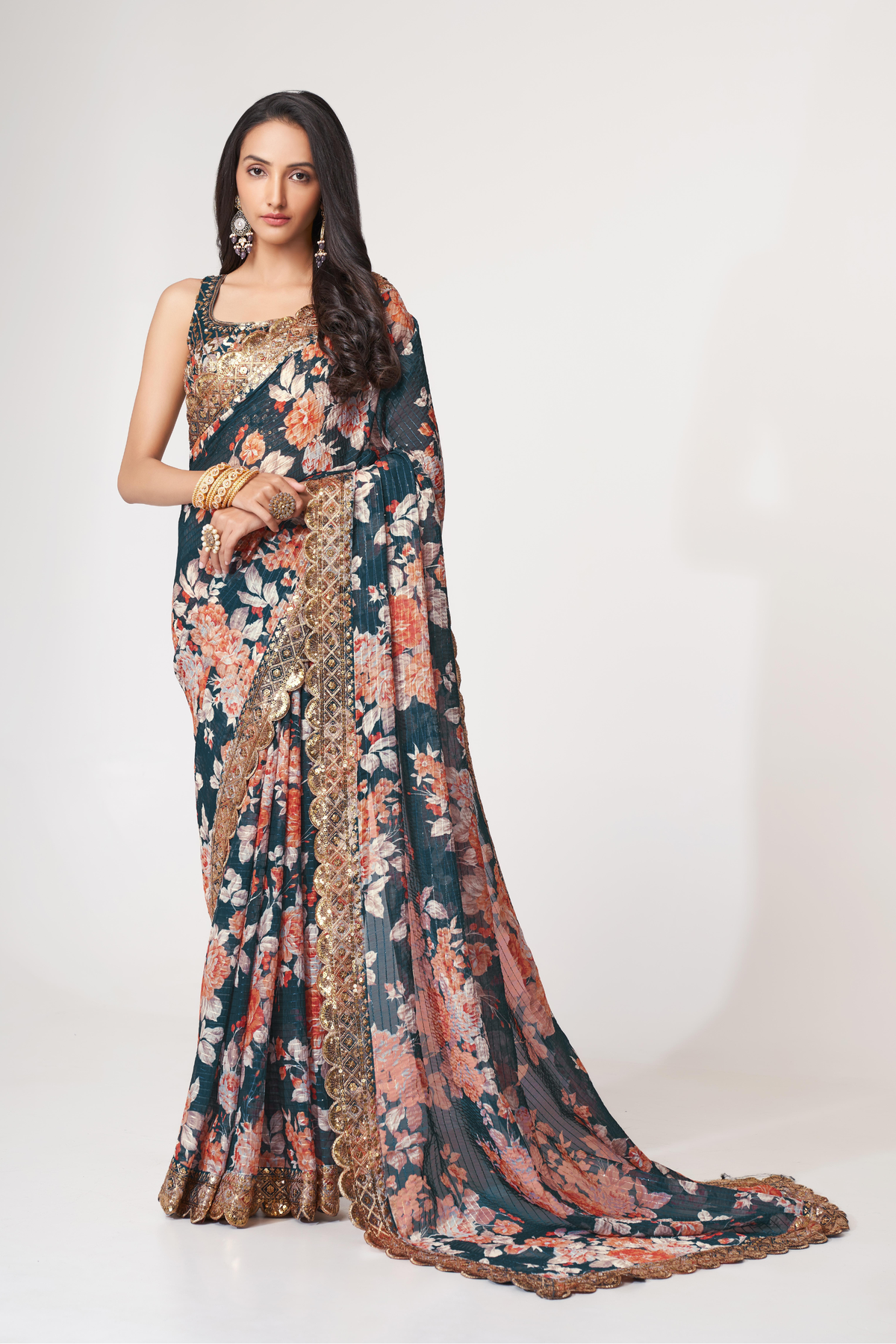Deep teal floral organza saree front view with peach blooms, zari sequins and matching embellished blouse