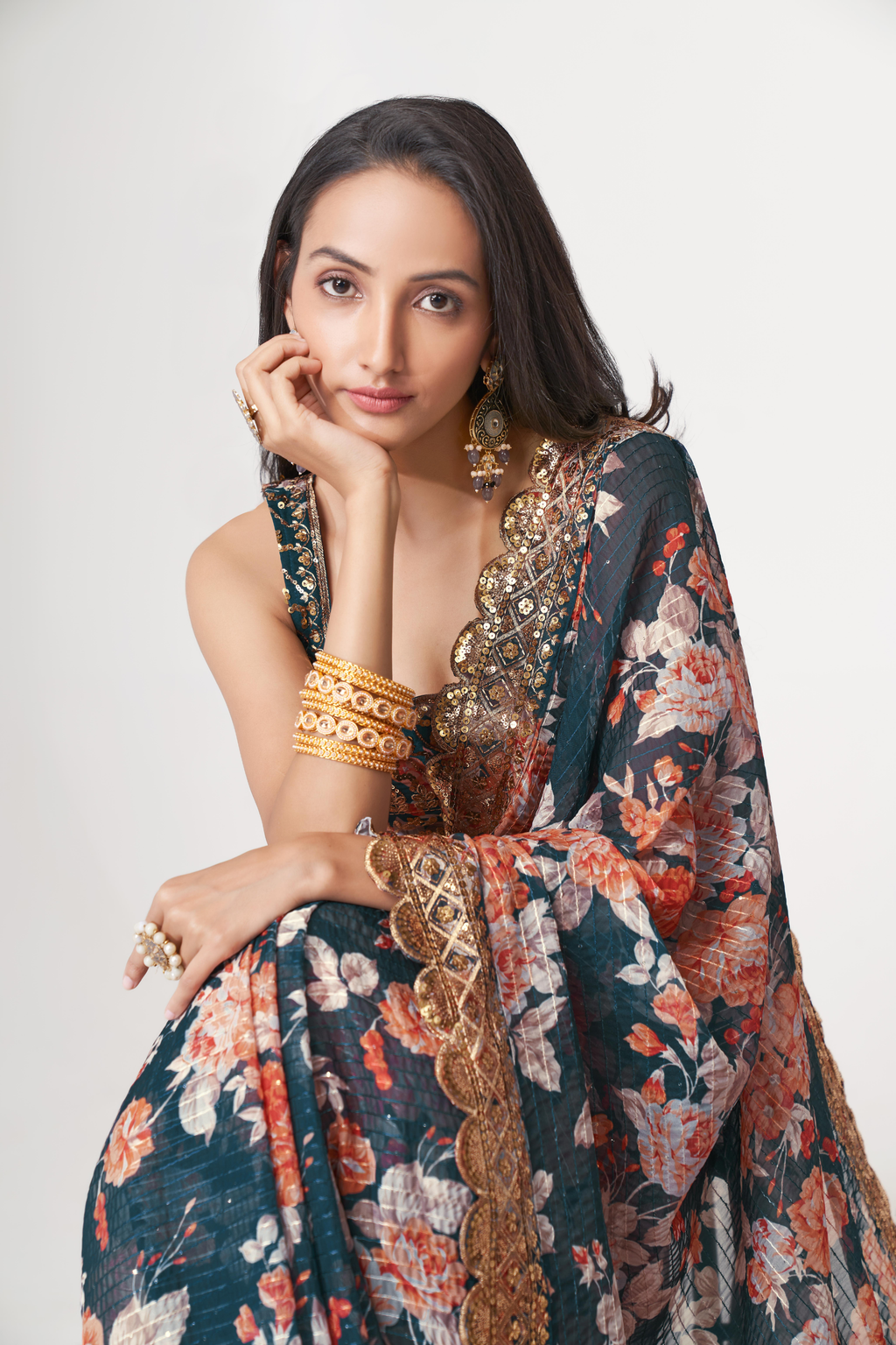 Full-length floral organza saree in deep teal with a gold border, peach flowers and elegant Nivi drape