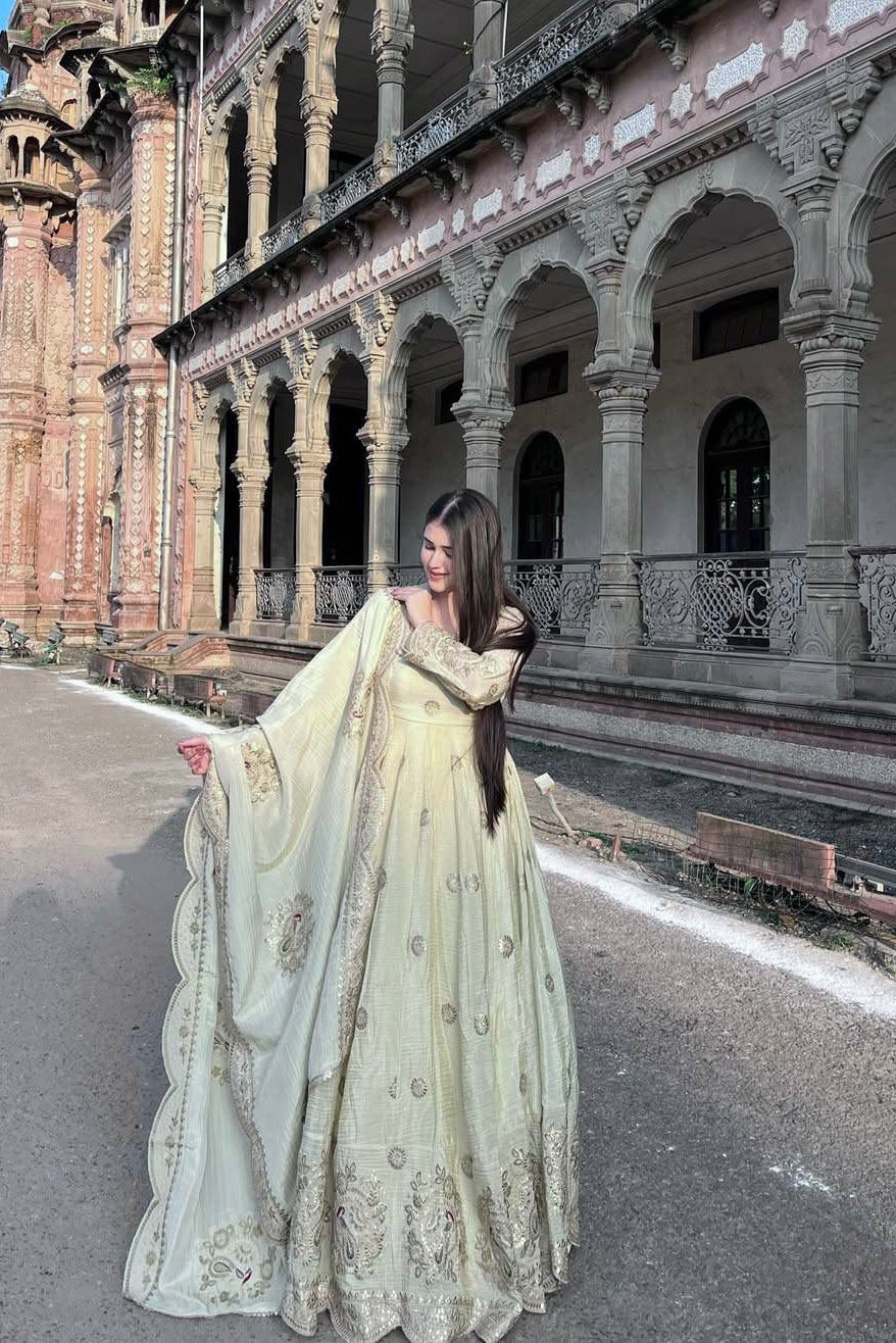 Embroidered Anarkali gown styled with its matching dupatta in a full-length outdoor fashion pose