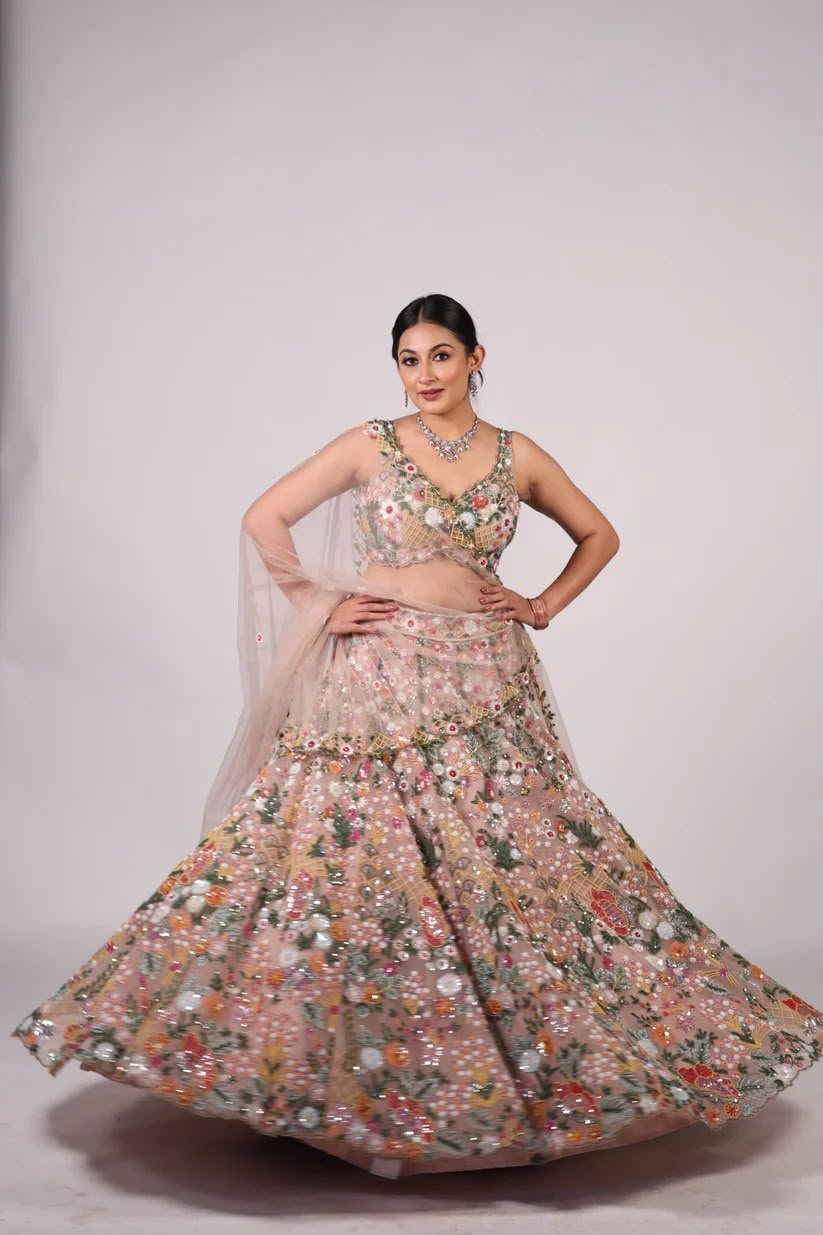 Floral net lehenga choli with colorful thread and sequin work in a studio setting