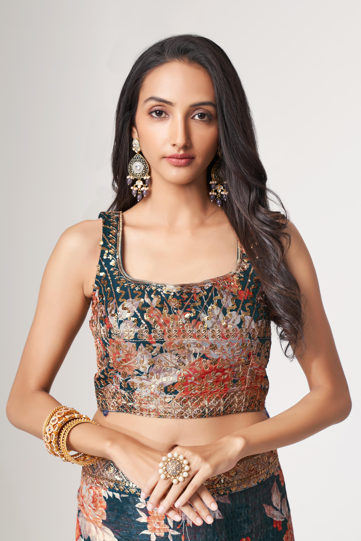 Floral organza saree styled with a teal pallu, gold embellished border and traditional Indian jewelry