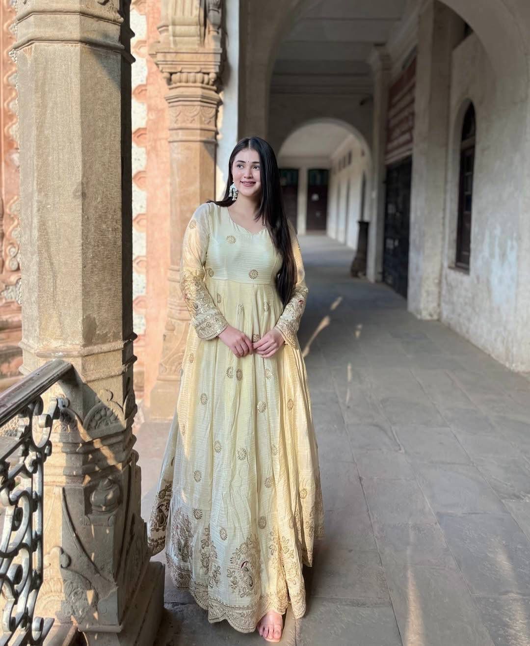 Indian Anarkali gown with embroidered sleeves and dupatta styled in a heritage palace corridor