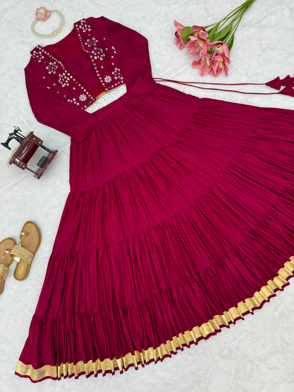 Magenta lehenga choli flat lay showing embroidered mirror-detail Koti and gold lace