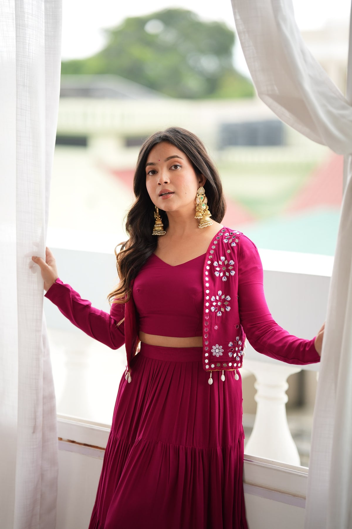 Magenta lehenga choli with embroidered Koti detailing styled for festive occasions