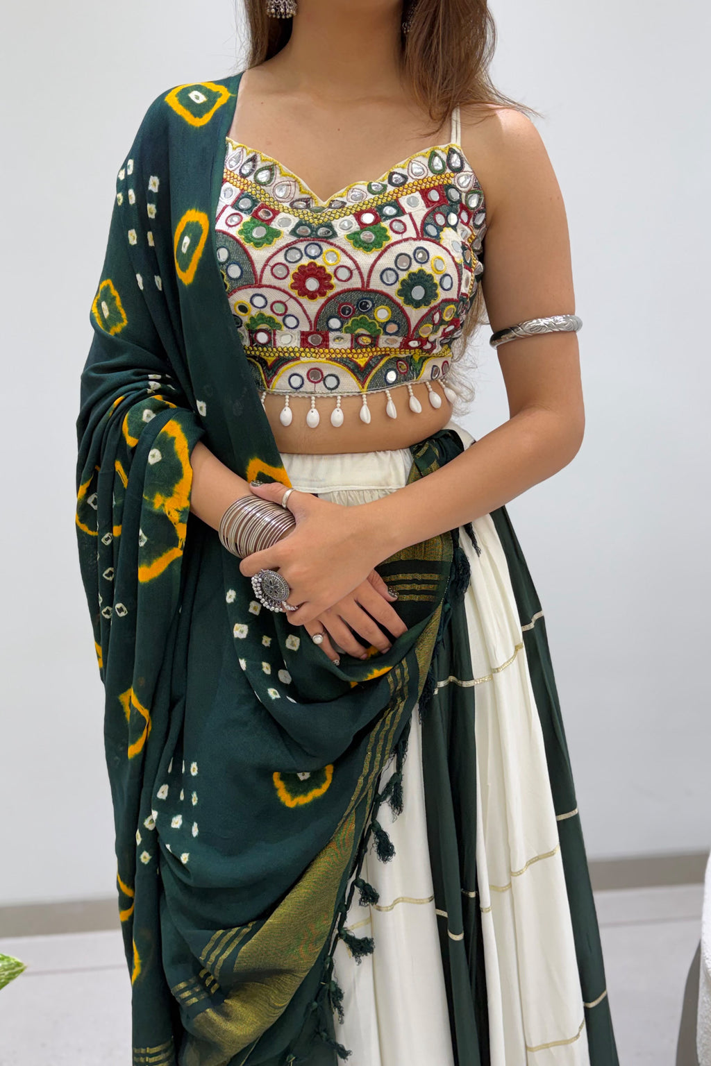 Close-up of mirror embroidered blouse with green Bandhni dupatta and festive lehenga