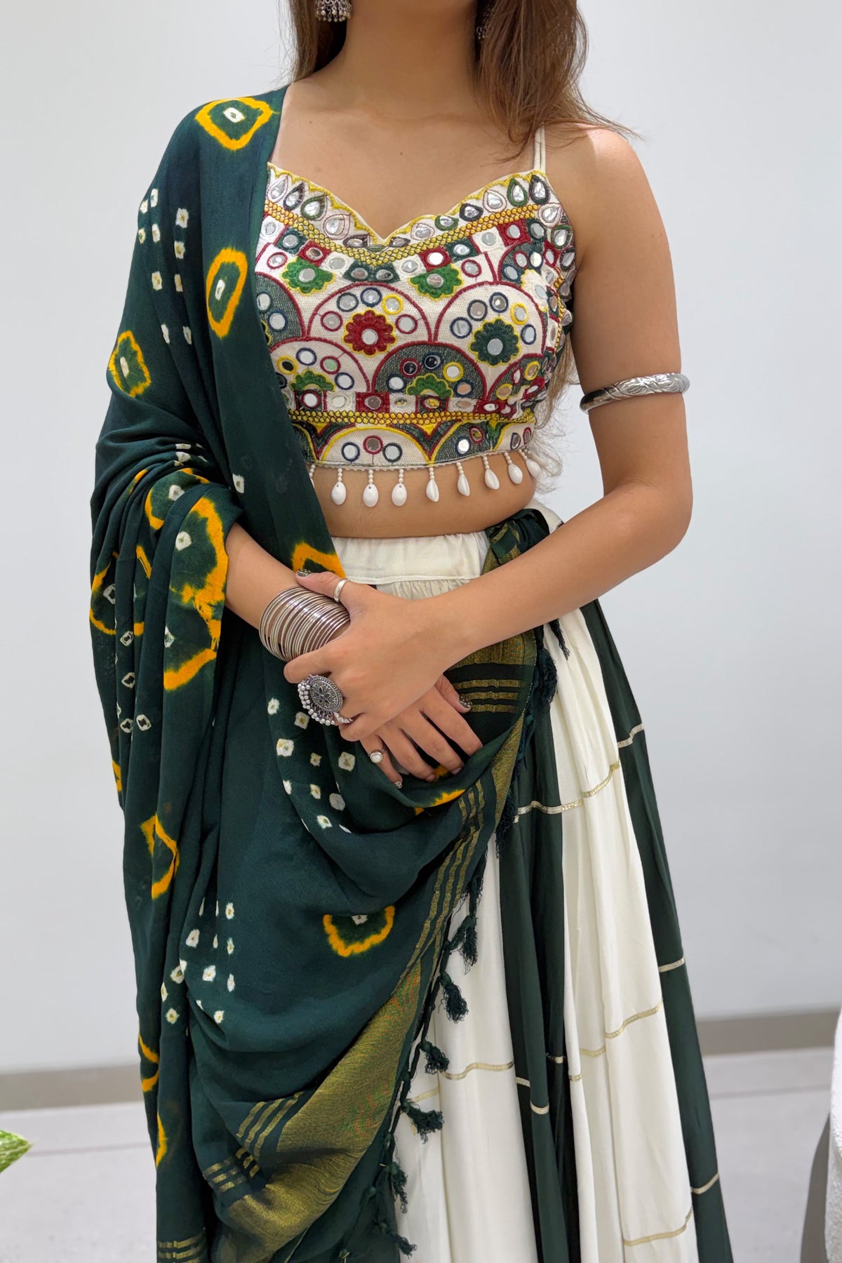 Close-up of mirror embroidered blouse with green Bandhni dupatta and festive lehenga