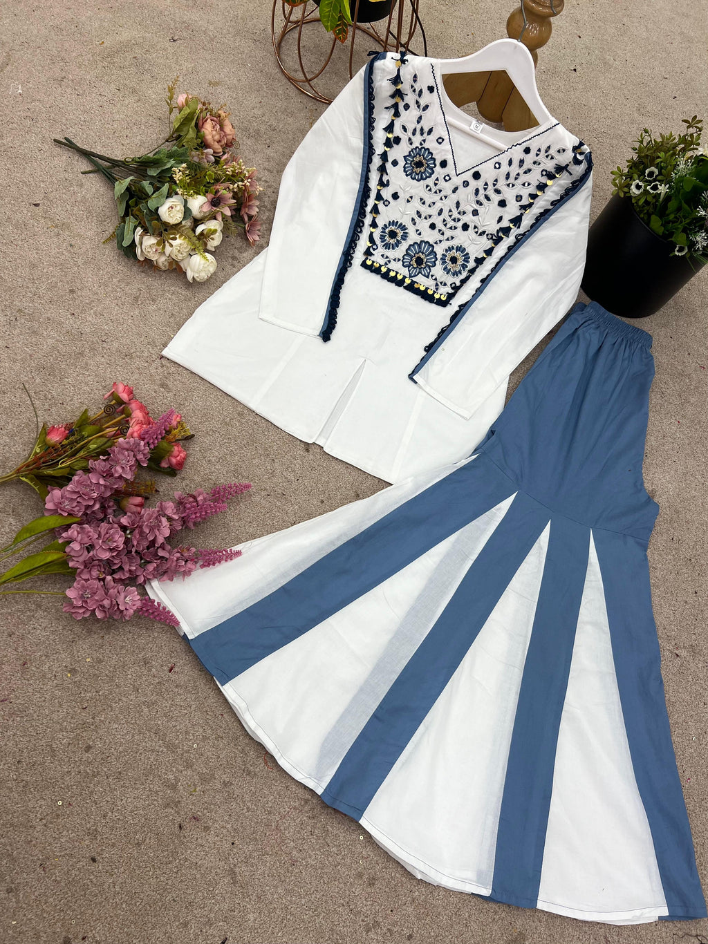 Close view of white embroidered kurta with blue mirror work and lace detailing