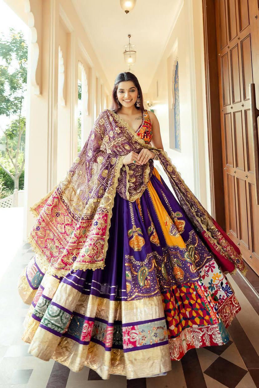 Purple and orange Navratri chaniya choli with mirror work and flared lehenga styled for festive wear