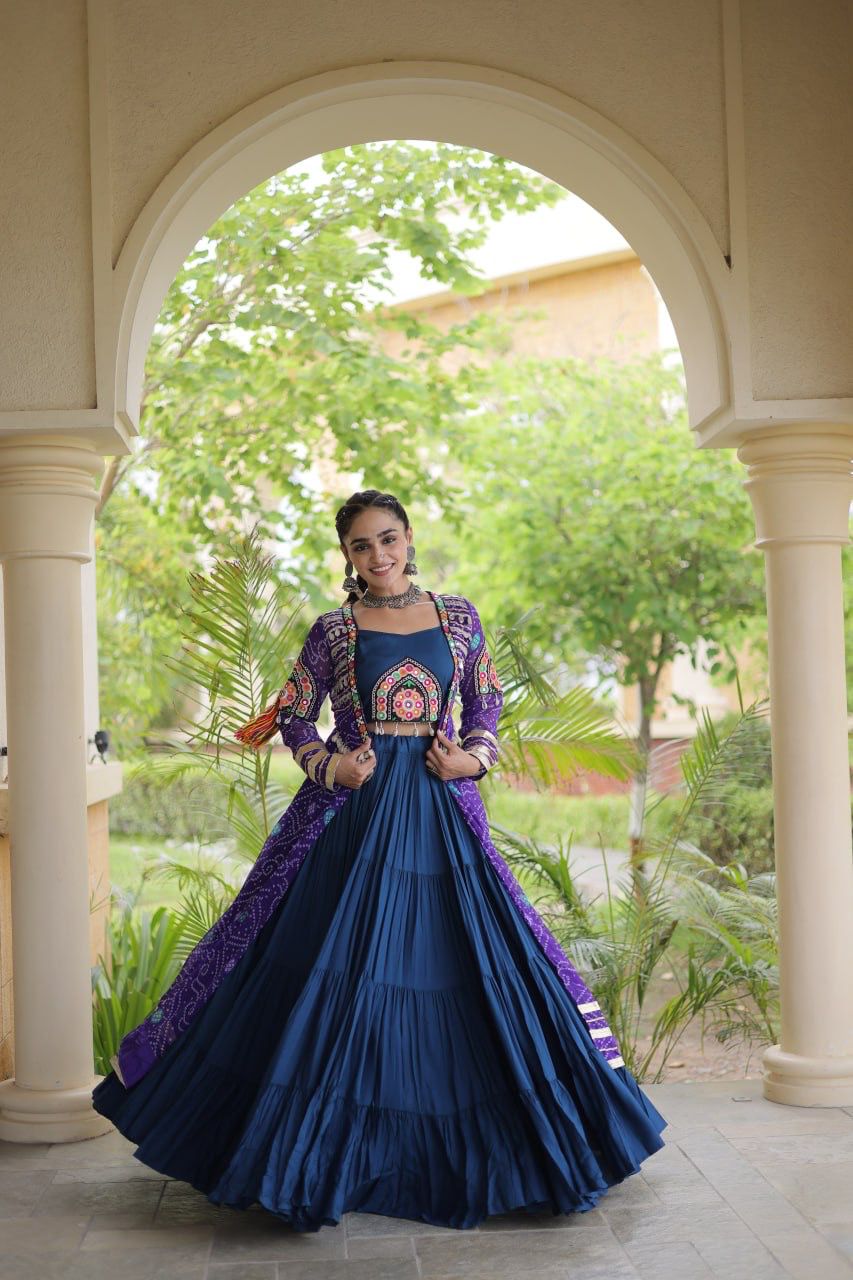 Front view of a flowing navy blue Navratri lehenga choli with purple printed shrug and colorful Kutchi patchwork