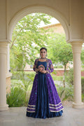 Purple Navratri lehenga choli with Kutchi patchwork shrug shown from the back in an elegant outdoor setting