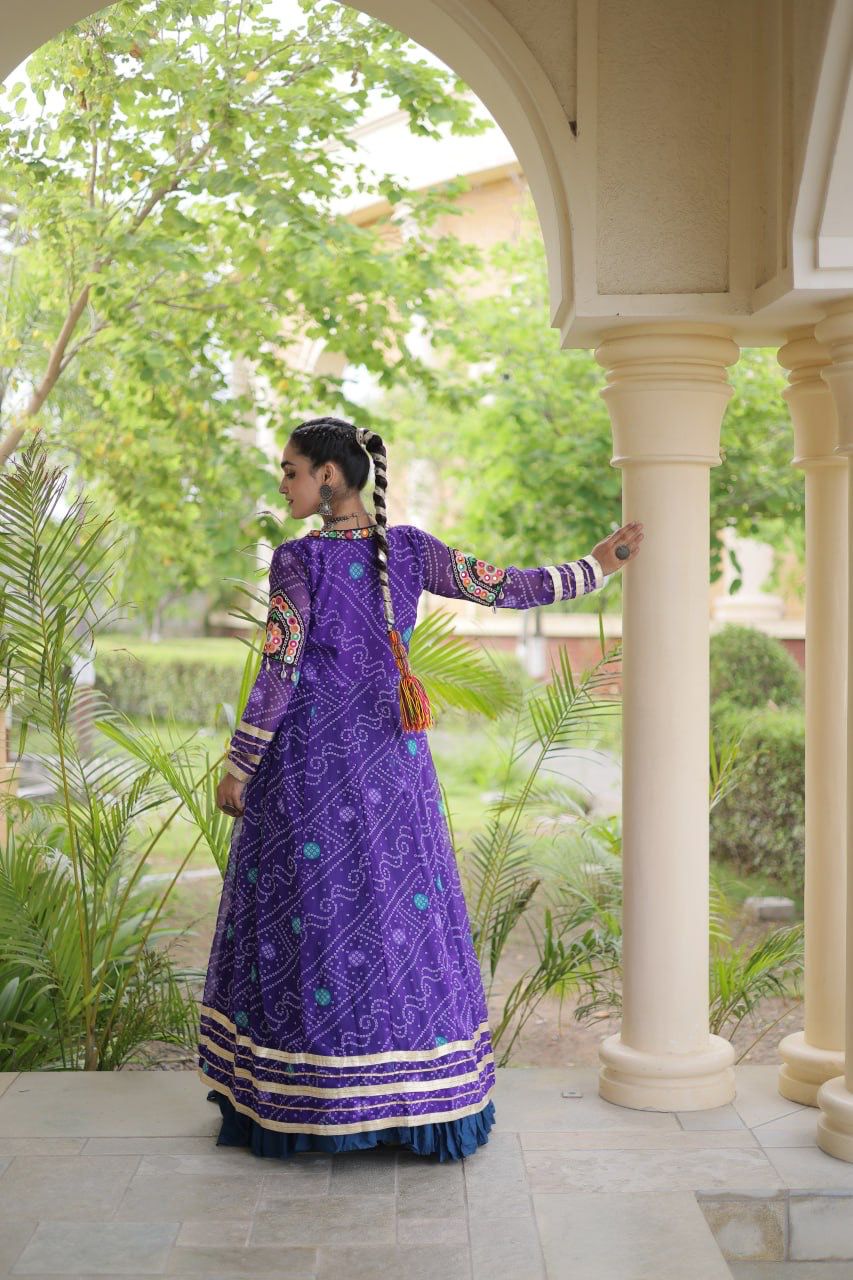 Navy blue and purple Navratri lehenga choli with full-length Kutchi patchwork shrug in a festive garden setting