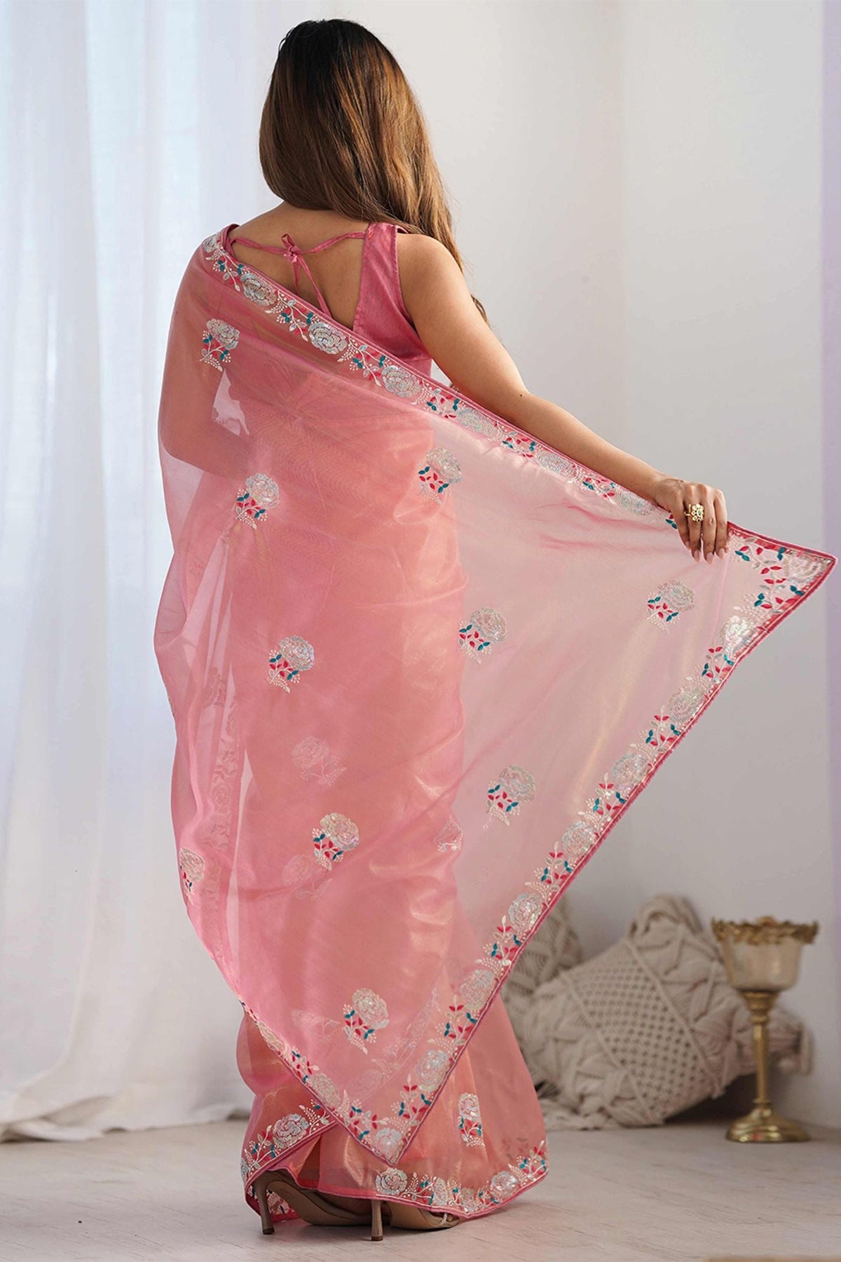 Peach silk saree back view showing floral embroidery and decorative border