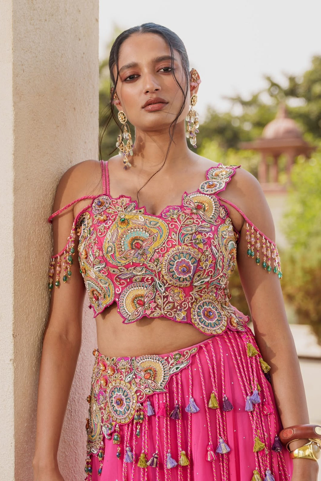 Close-up of pink embroidered lehenga choli blouse with multicolour threadwork and sequins