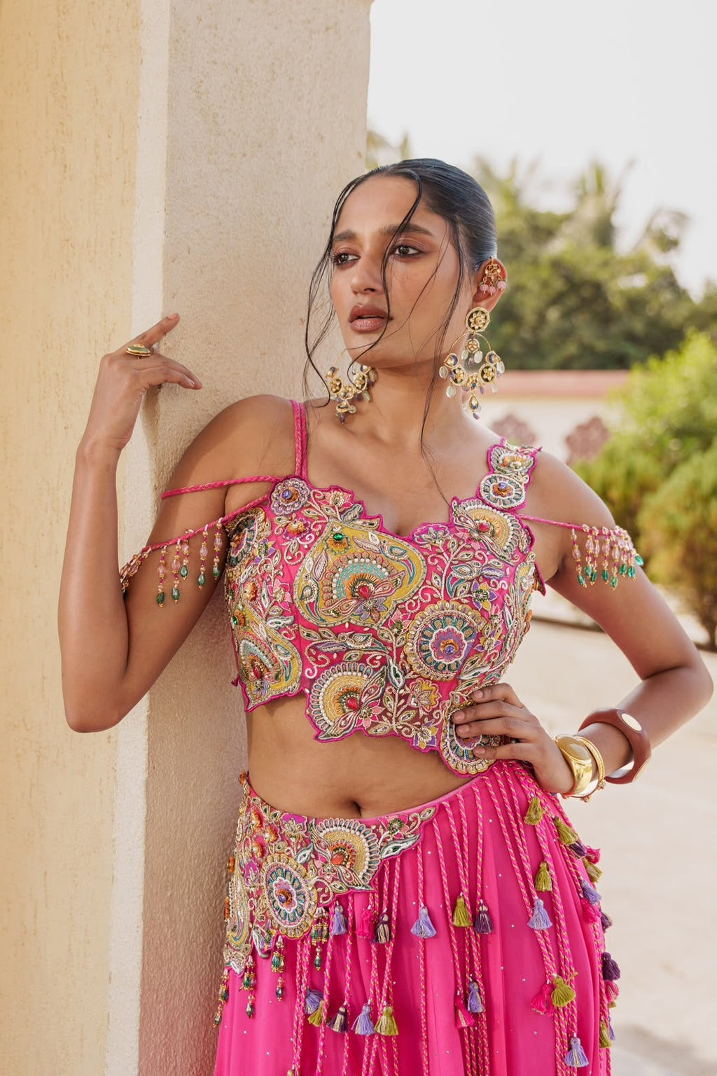 Pink embroidered lehenga choli model look featuring detailed blouse and multicolour tassels