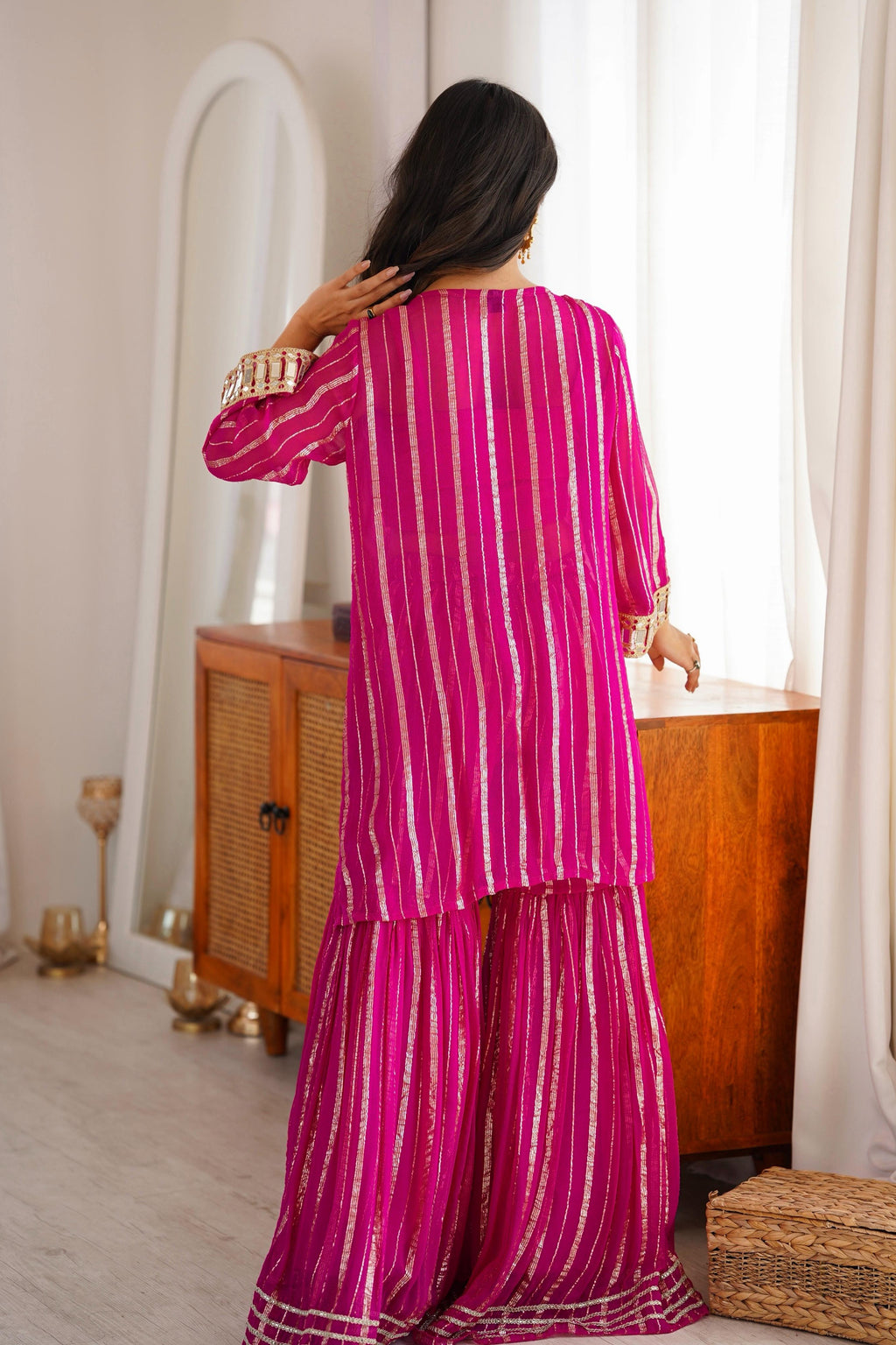 Back view of pink sharara suit showing the striped Gold Zari fabric and flared silhouette