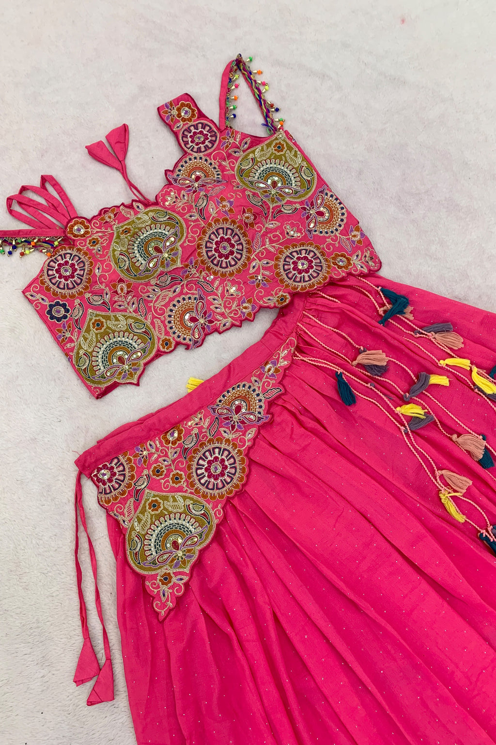 Pink Vichitra Silk lehenga choli showing embroidered blouse, waistband and colourful tassels