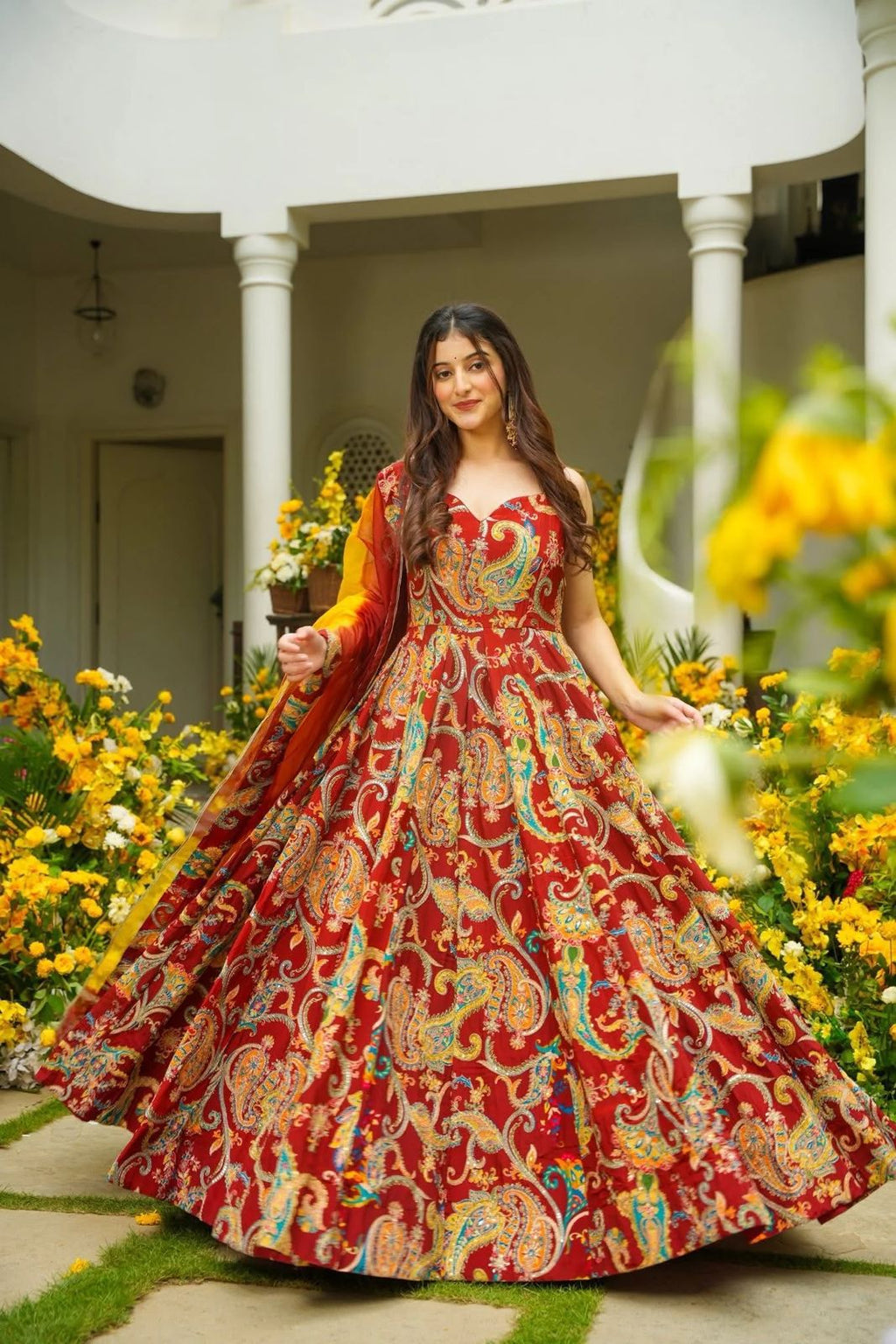 Full-flair view of a red printed Anarkali gown with contrasting yellow dupatta