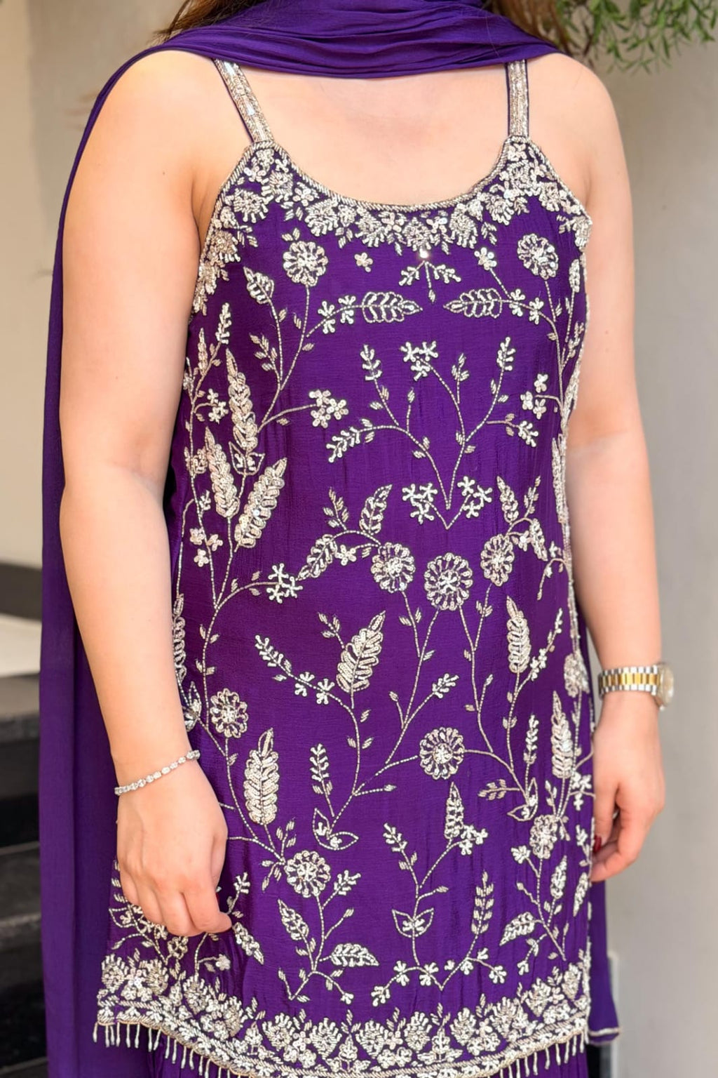 Detailed view of floral embroidery and embellished border on purple Chinon suit