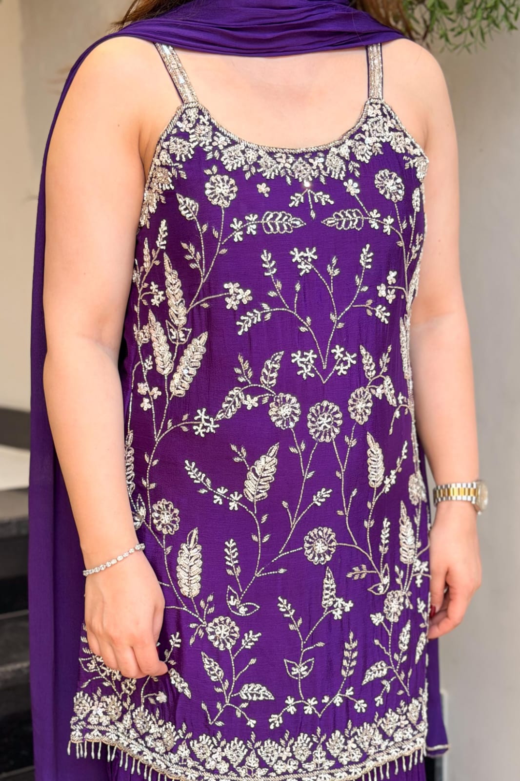 Detailed view of floral embroidery and embellished border on purple Chinon suit