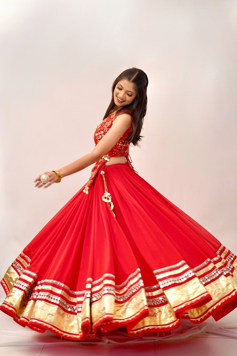 Back detail of red lehenga choli showing the embellished choli and flowing skirt