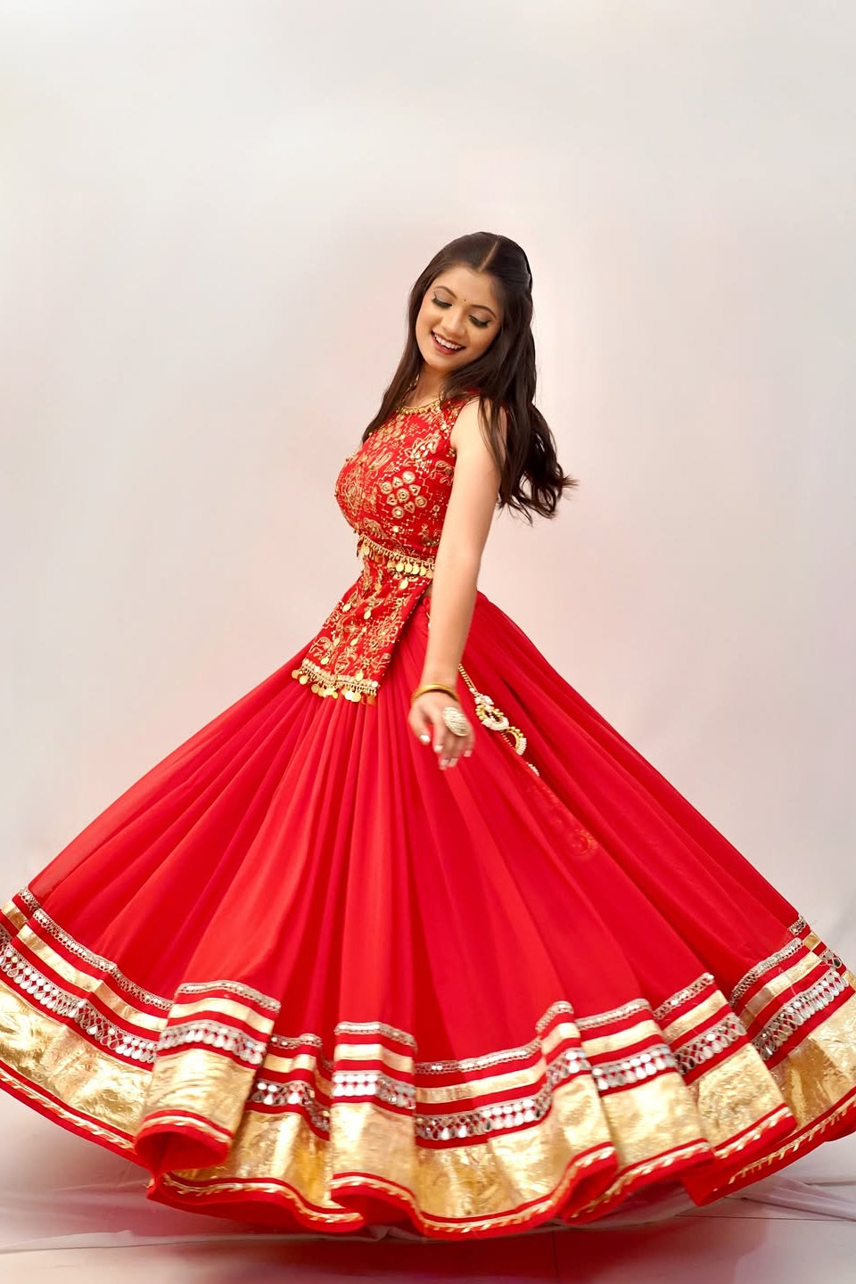 Fully stitched red lehenga choli styled with an embroidered choli and traditional detailing