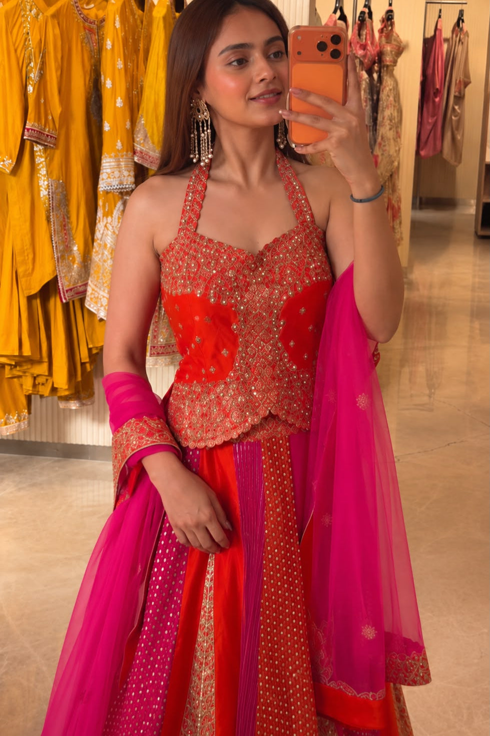 Close-up of red pink embroidered choli with sequin detailing and matching butterfly net dupatta