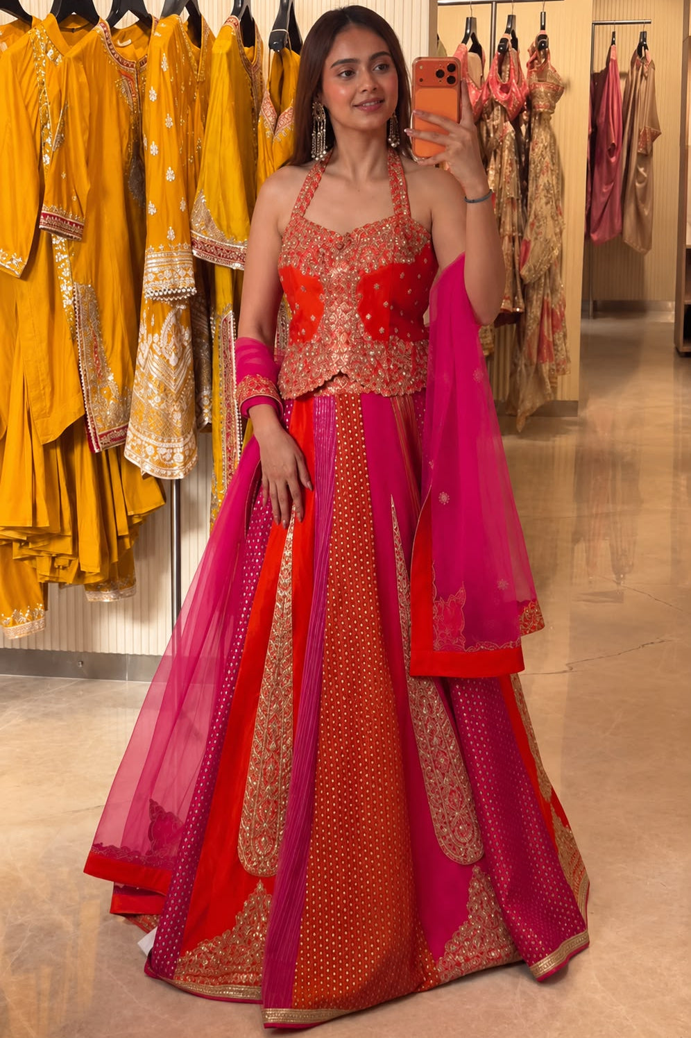 Red pink embroidered lehenga choli styled with butterfly net dupatta in a boutique setting