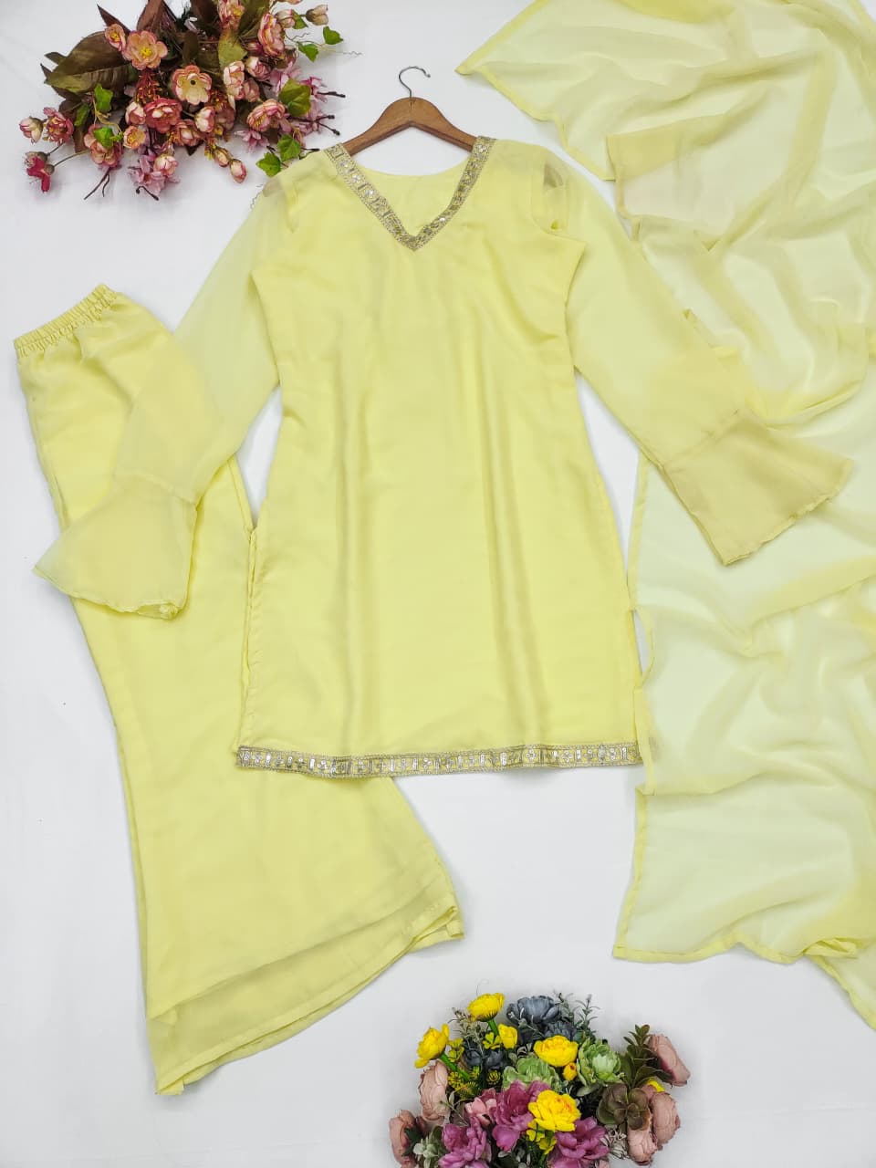 Close-up of V-neckline with sequin and mirror embroidered border on yellow kurti