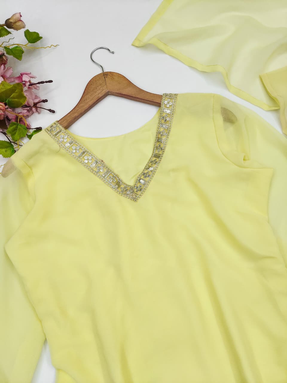 Yellow palazzo suit set flat lay showing embroidered hemline border detail